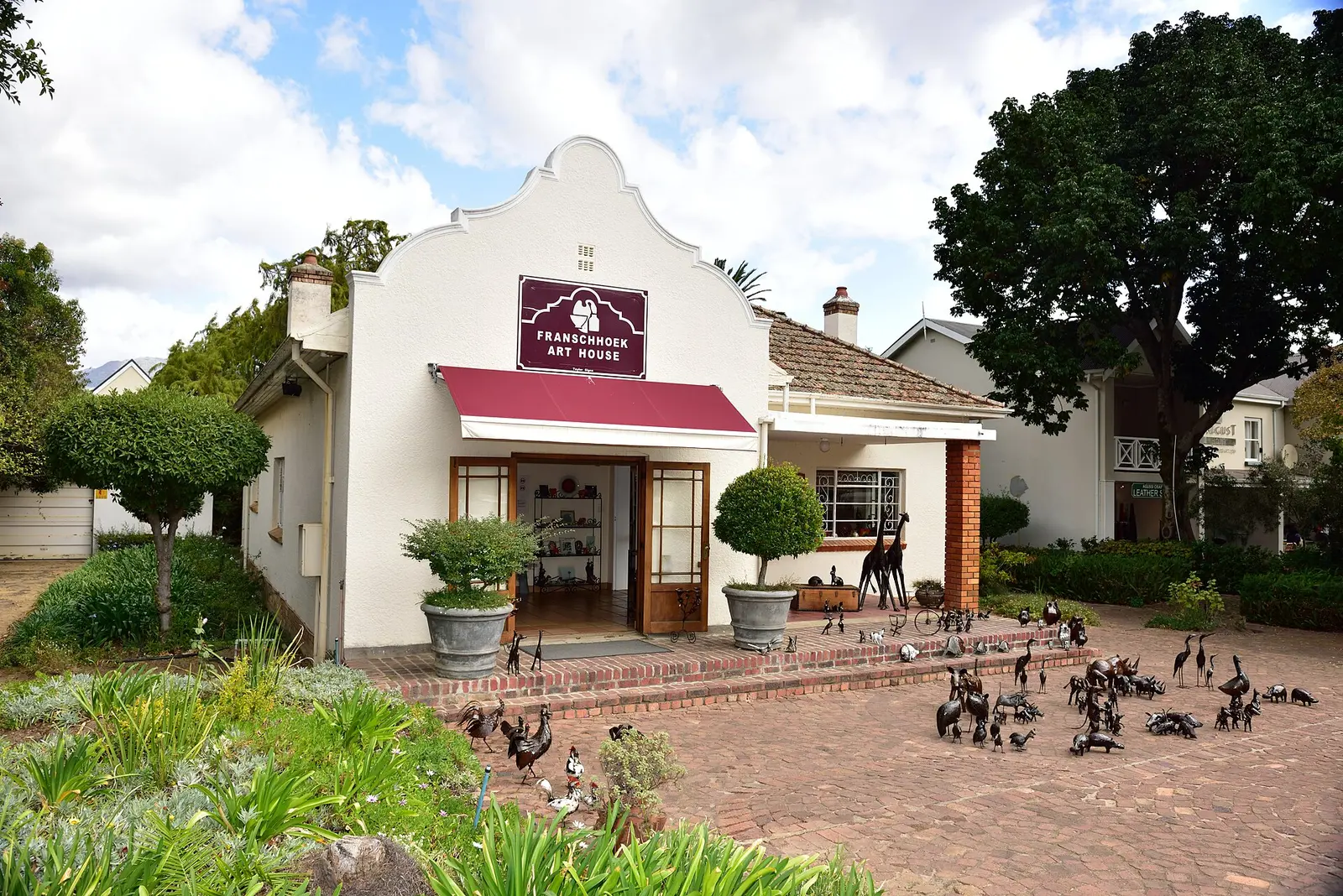 The Franschhoek Art House, a whitewashed Cape Dutch gallery building with a brick courtyard
