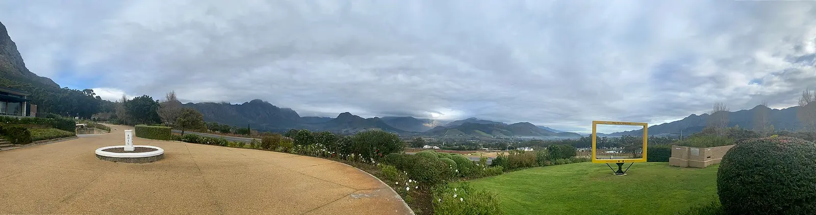 Gardens and lawns with the Franschhoek mountains under cloud in the Western Cape